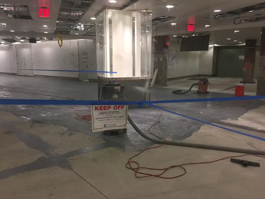 Freshly applied resinous floor coating with a keep-temperature-up curing notice, Bismarck ND coatings